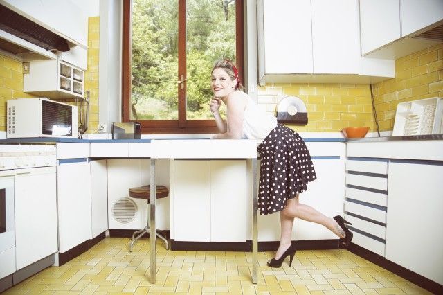 Portrait of young woman in vintage clothes in vintage kitchen